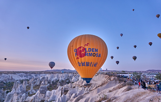 Goreme, Turkey - October  25, 2020: Colorful hot air balloons flying early in the morning over the valley at Cappadocia, Nevsehir, Turkey.