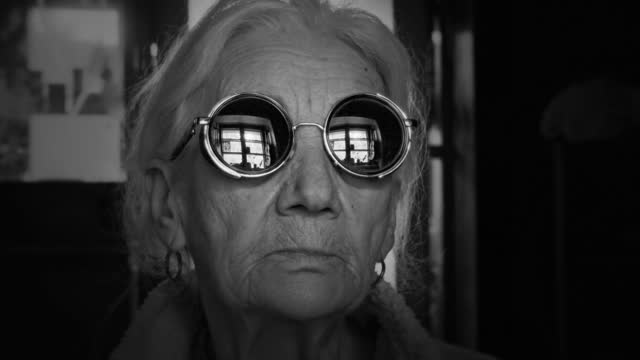 Old woman in mirror sunglasses.