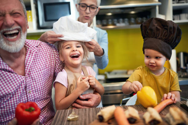 niños con sombrero de chef en la cabeza divirtiéndose - cake birthday domestic kitchen child fotografías e imágenes de stock