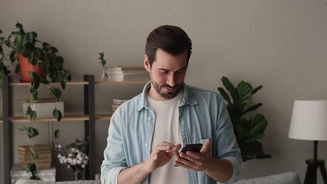 Young business man with smart phone standing indoor