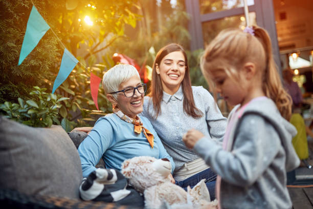 istock Child with mom and grandmom watching gift 1310602054