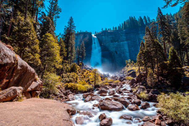 Long exposure at Vernal Falls from the bottom one summer morning and the sun above. California, United States"t Long exposure at Vernal Falls from the bottom one summer morning and the sun above. California, United States"t yosemite falls stock pictures, royalty-free photos & images