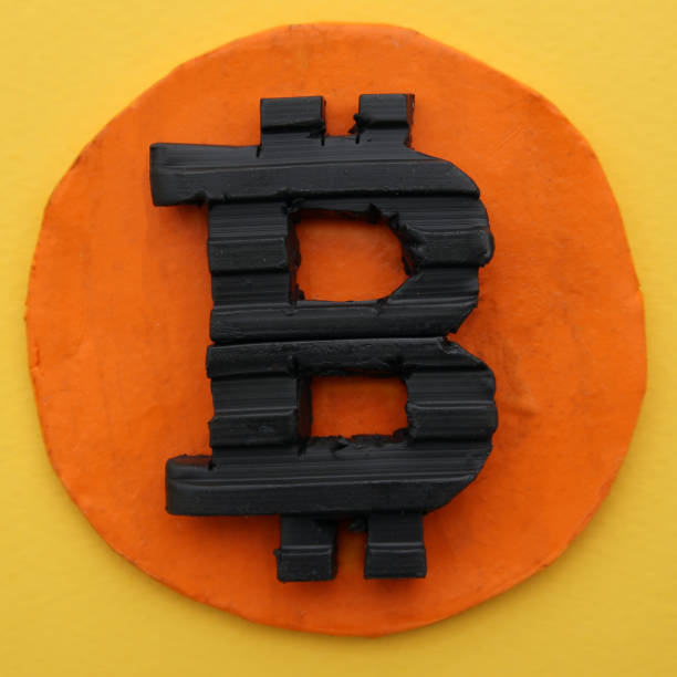 istock Black Bitcoin symbol on a circular golden orange base. Real three dimensional model flat lay 1310603241