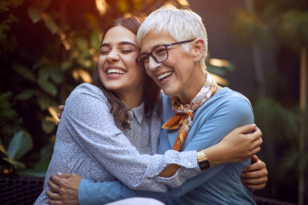 córka obejmując jej uśmiechniętą matkę. - family grandmother child happiness zdjęcia i obrazy z banku zdjęć