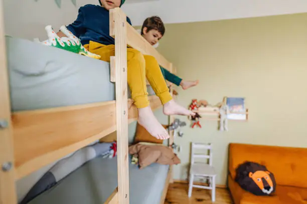 Photo of little boys playing with toys on their bunkbed