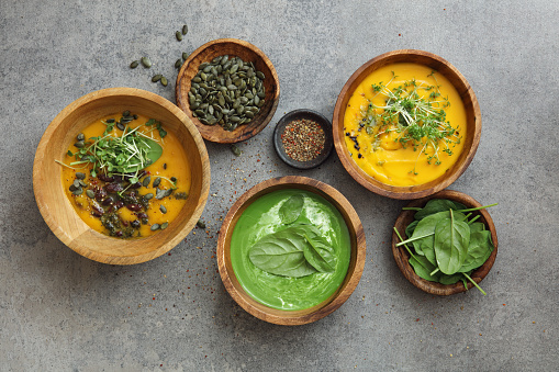 Vegetarian creamy broccoli spinach soup is topped with spinach leaves and pumpkin seeds. Gluten-Free creamy vegan carrot soup with coconut. Roasted pumpkin soup with beans.