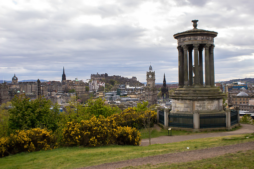 The Dugald Stewart Monument, in memorial to the famous Scottish philosopher, on Calton Hill, on a spring afternoon with a spectacular view of Castlerock and the Edinburg Castle and Old town in the background