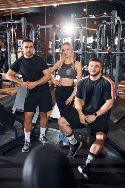 istock Two athletic guys and gym coach posing for a camera 1310613608