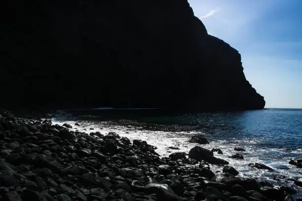 Canary Islands, Spain. Beach with large black volcanic boulders between cliffs.