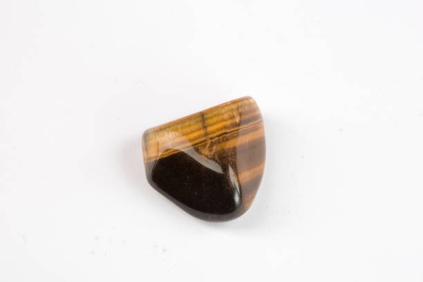 istock Natural tiger eye stone isolated on white background. Horizontal close-up. 1310614514