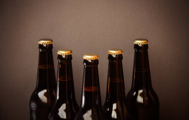 istock Glass bottles of beer on brown background. Selective focus. 1310616093