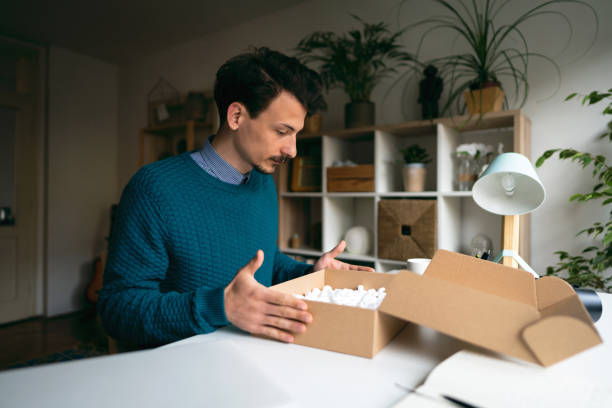istock Young man feeling disappointed after he unpacking a parcel with the wrong order at home 1310616692