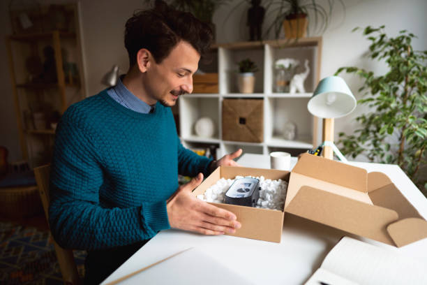 istock Cheerful young male customer opening delivery package at home 1310616713