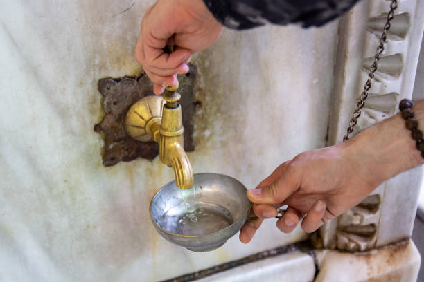 mann gießt sich eine tasse wasser - istanbul people faucet turkey stock-fotos und bilder