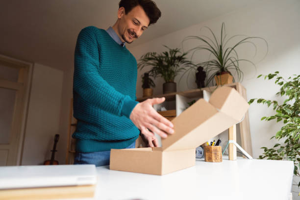 istock One smiling Caucasian male customer opening delivery package at home 1310616821