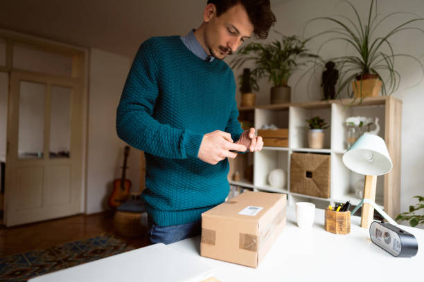 istock Man taking a picture of a bar code on a package label with smart phone to file a reclamation 1310616828