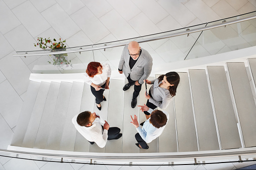 Group of business people talking on the stairs.