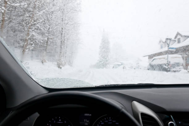 gefährliches fahren auf eisiger landstraße während eines schneesturms auf dem hügel - drivers point of view country road snowing blizzard stock-fotos und bilder