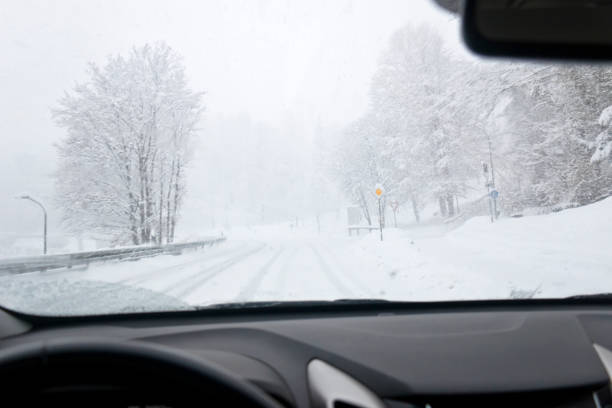 fahren unter extremen winterbedingungen während eines schneesturms - drivers point of view country road snowing blizzard stock-fotos und bilder