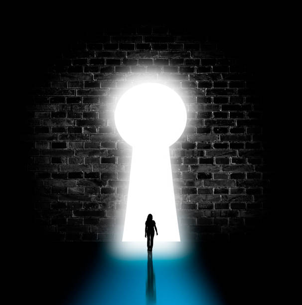 istock Silhouette of a woman through a bright keyhole 1310622980
