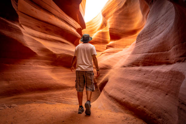 un giovane turista con una camicia bianca in una crepa in lower antelope"t - canyon lower antelope foto e immagini stock