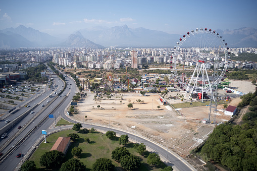 Picturesque urban landscape of Antalya town, Turkey. View of cityscape, Ferris Wheel and beautiful nature.