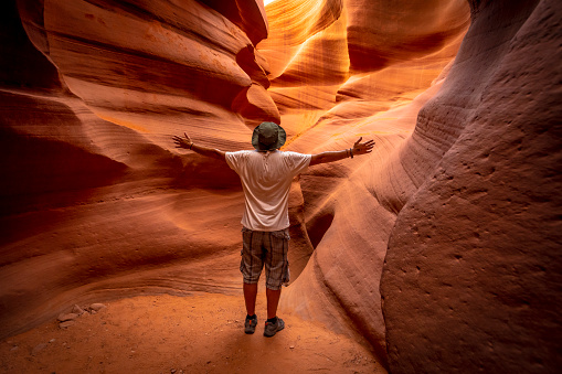 A young tourist with a white shirt in a crack in Lower Antelope\