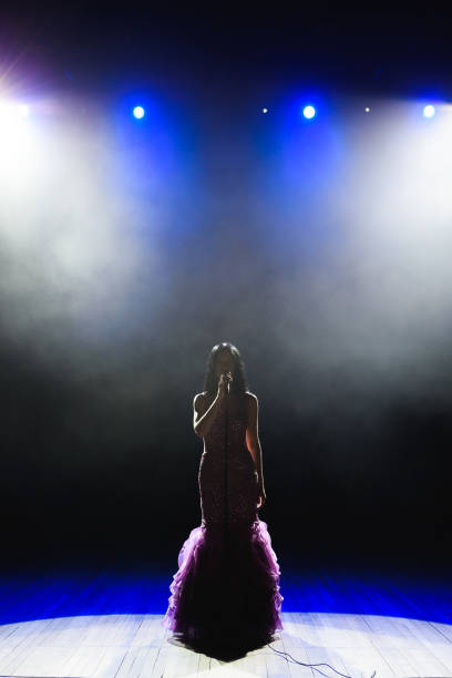 istock Female singer on the stage holding a microphone. 1310625045