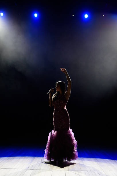 istock Female singer on the stage holding a microphone. 1310628201