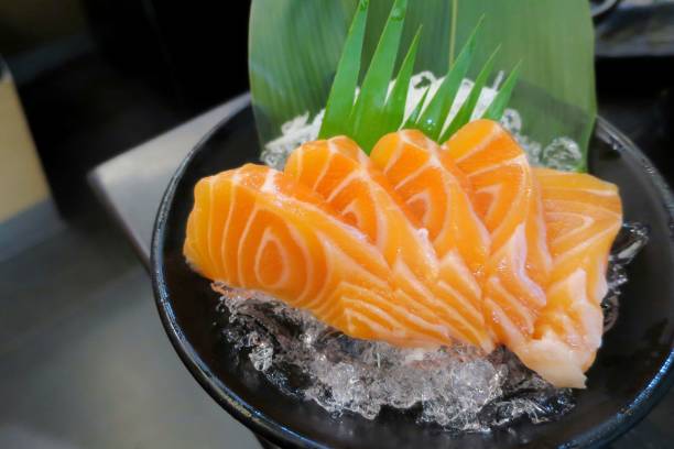 salmon sashimi on ice in black plate. - buffet japanese cuisine lifestyles ready to eat imagens e fotografias de stock