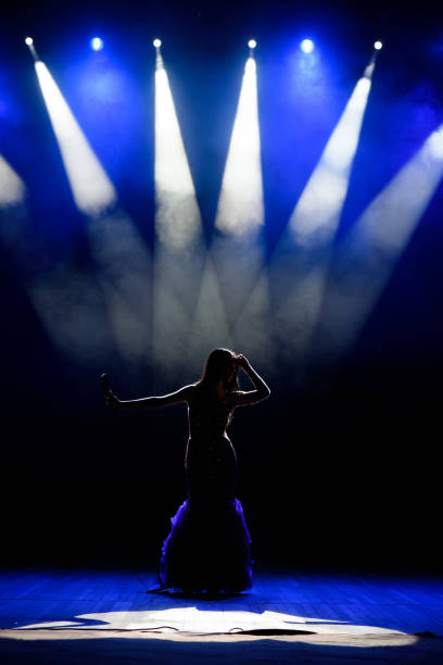 istock A young woman singer on stage during a concert. 1310628232
