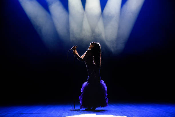 istock A young woman singer on stage during a concert. 1310628236