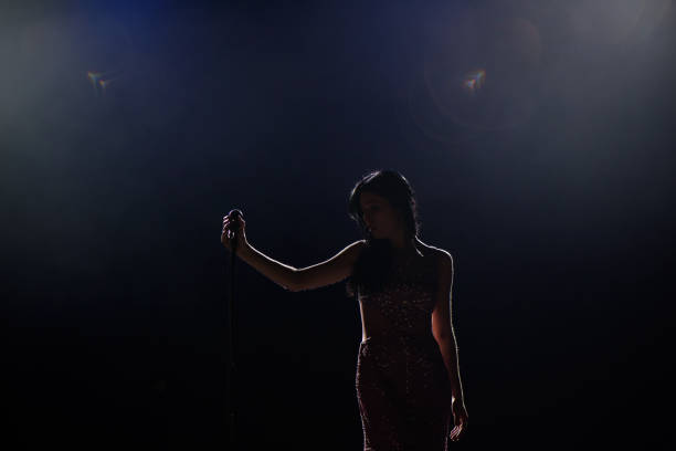 istock Female singer on the stage holding a microphone. 1310628321
