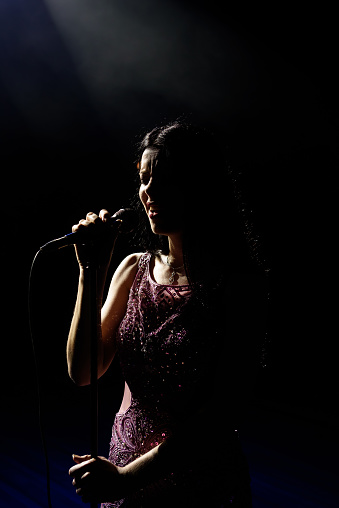 Singer woman on stage. Female singer on the stage holding a microphone