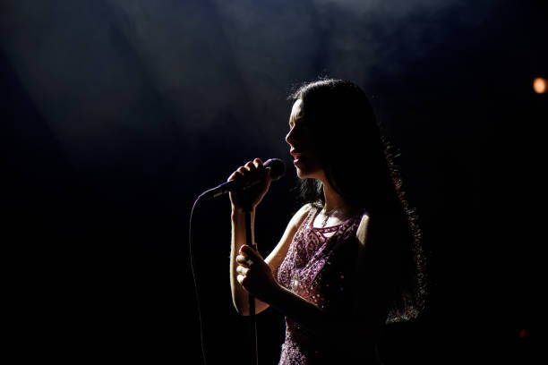 어두운 배경에 아름다운 노래 여자의 초상화. - singer singing women microphone 뉴스 사진 이미지