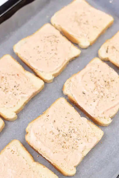 Photo of Baked Sandwiches with ham and cheese on the baking tray