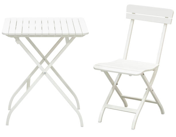 White garden folding chairs and folding table in front of white background