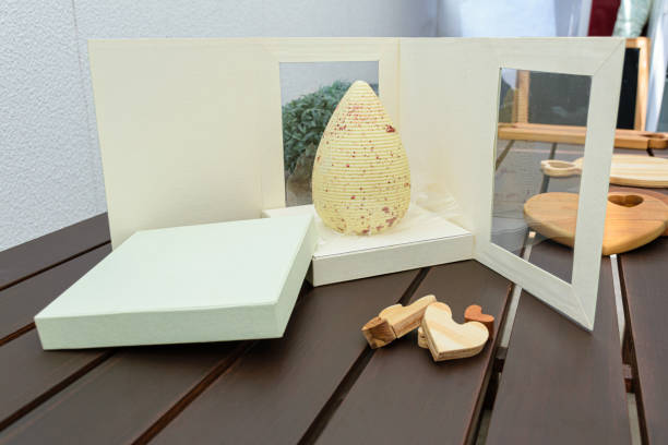istock White chocolate Easter egg with edible copper-colored paint. On an open white box. Beside wooden hearts. 1310640275