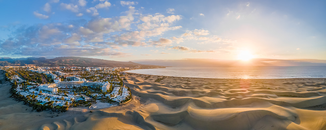 Paisaje con la ciudad de Maspalomas y dunas de arena dorada al amanecer photo