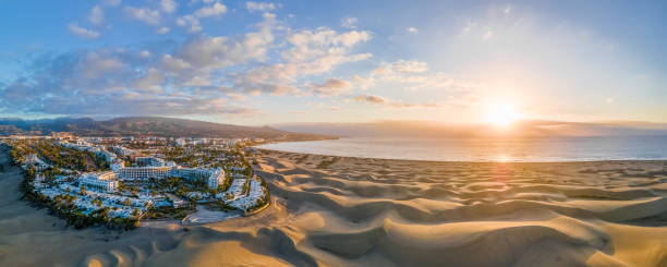 Landscape with Maspalomas town and golden sand dunes at sunrise Landscape with Maspalomas town and golden sand dunes at sunrise, Gran Canaria, Canary Islands, Spain canary photos stock pictures, royalty-free photos & images