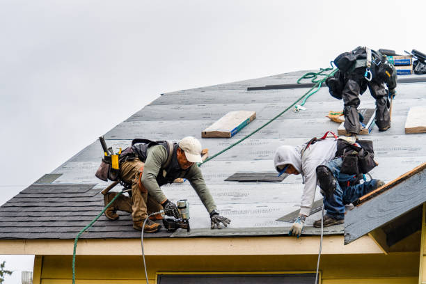 załoga instalując nowe gonty na dachu w deszczowy dzień - roof repairing tile construction zdjęcia i obrazy z banku zdjęć