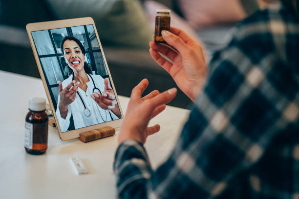 若い女性のビデオは医者とチャットします。 - pill bottle pill stethoscope medical exam ストックフォトと画像