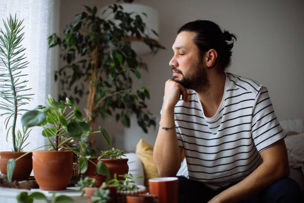 istock Man holding coffee cup while looking away at home 1310649767