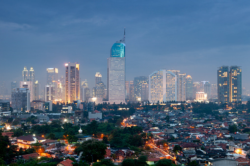 View of the city skyline illuminated at dusk in Jakarta, Indonesia.