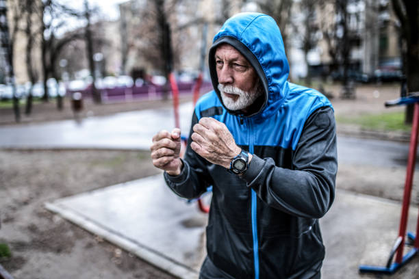 istock Senior male fighter shadow boxing outdoors on cold and rainy day. 1310652781