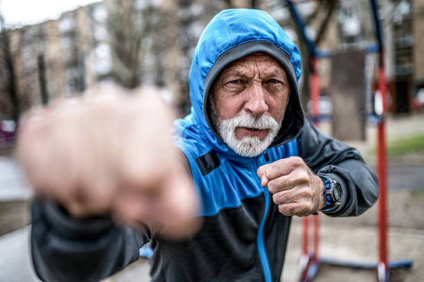 istock Senior male fighter shadow boxing outdoors on cold and rainy day. 1310652789