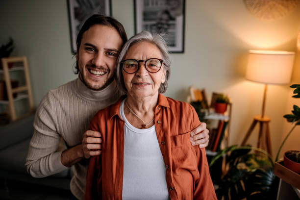 emozioni - senior adult child holding grandparent foto e immagini stock