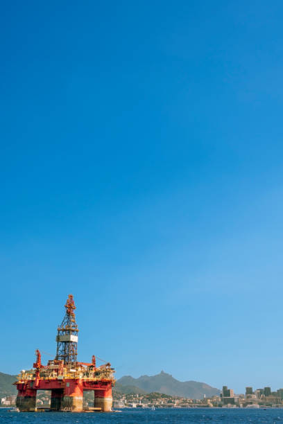Metal tower with chains for lifting. Crane atop a building under a clear blue sky