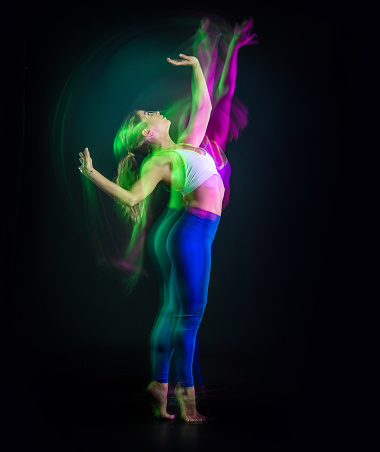 Dancer practicing with pink and green light slow motion effects