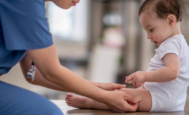 istock Doctor Placing A Band Aid On Baby's Thigh 1310664372